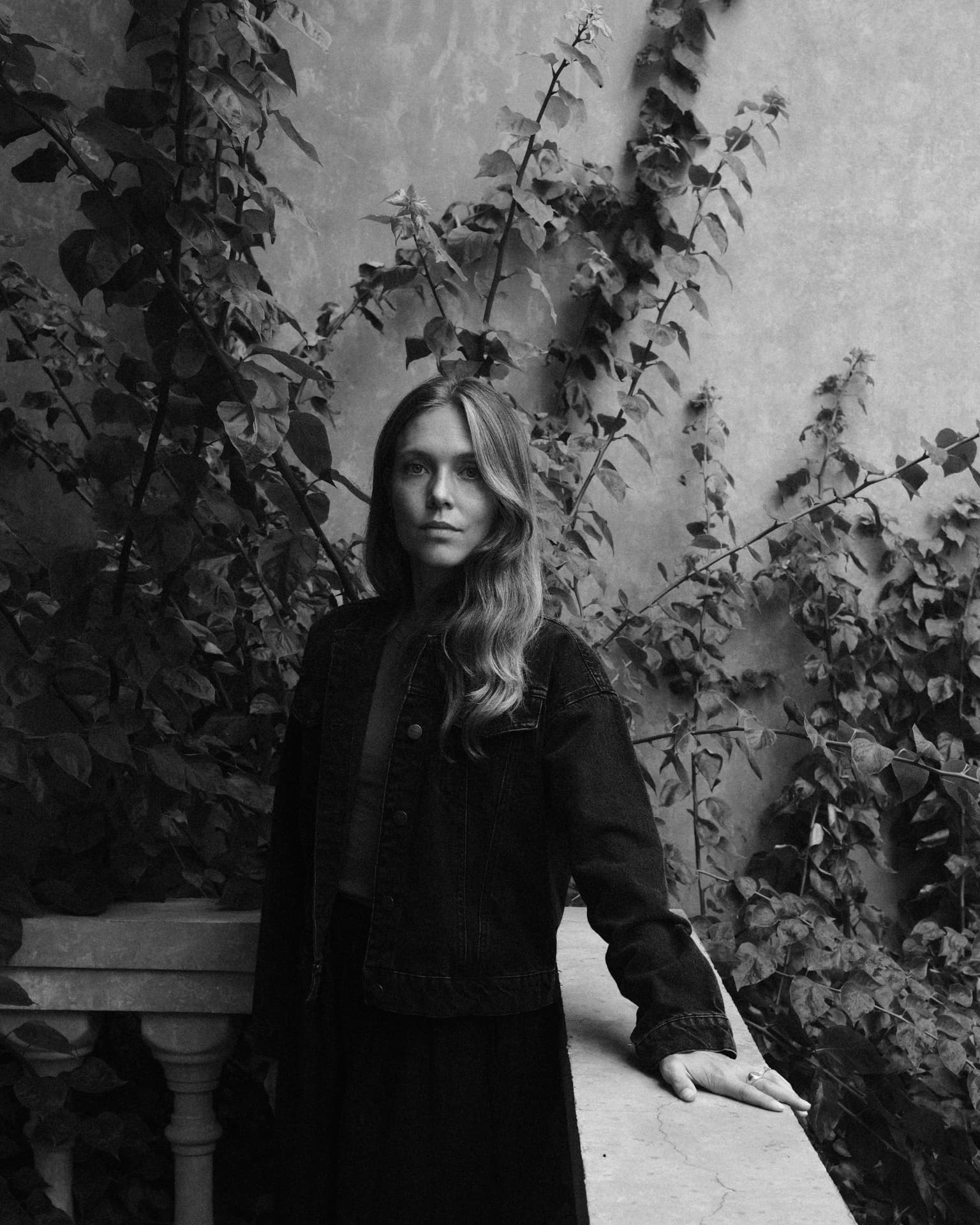 Portrait of brand photographer Marie-Louise Hald in soft daylight against a plaster wall